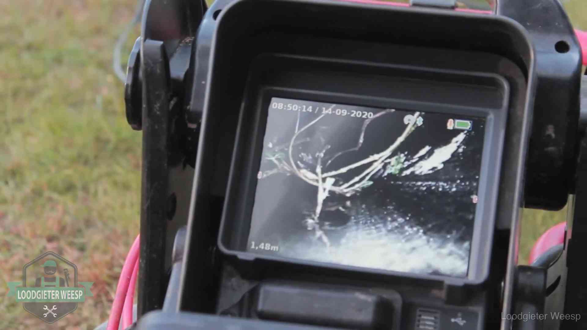 Monitor van een rioolcamera toont wortelingroei in de rioolbuis bij een woning in Weesp