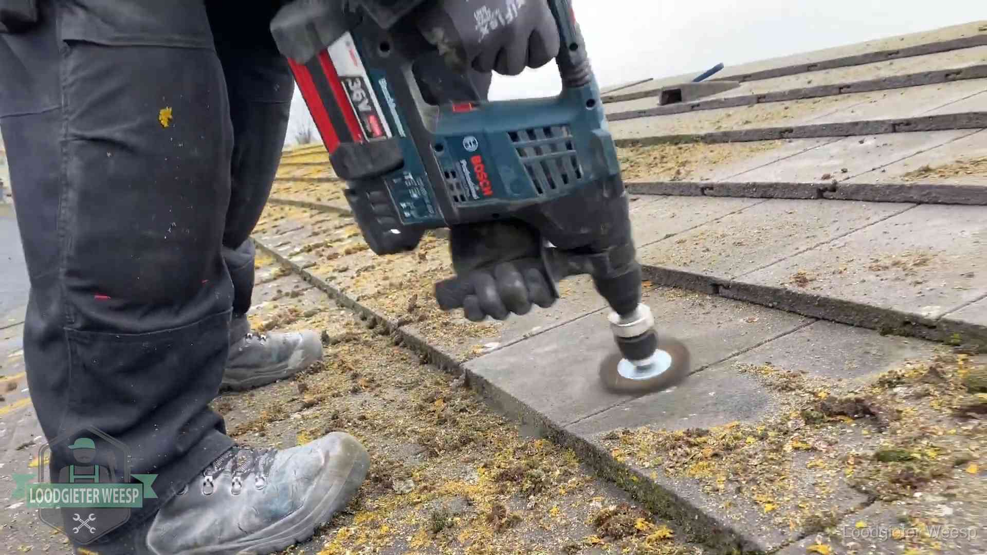 Betonnen dakpannen worden machinaal gereinigd tijdens dakonderhoud in Weesp