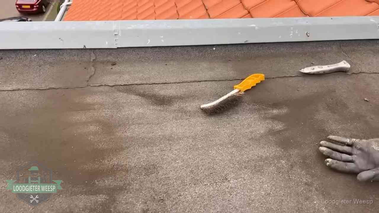 Dakdekker bereidt een bitumen plat dak voor op reparatie bij de daktrim in Weesp