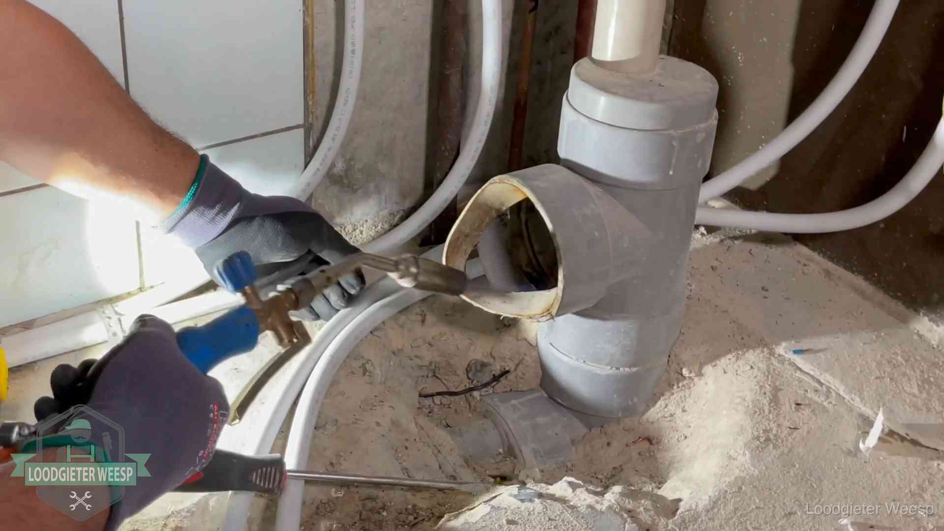 Vakmanschap van onze loodgieters in Weesp Loodgieter werkt met brander en messing kraanwerk aan leidingen in Weesp