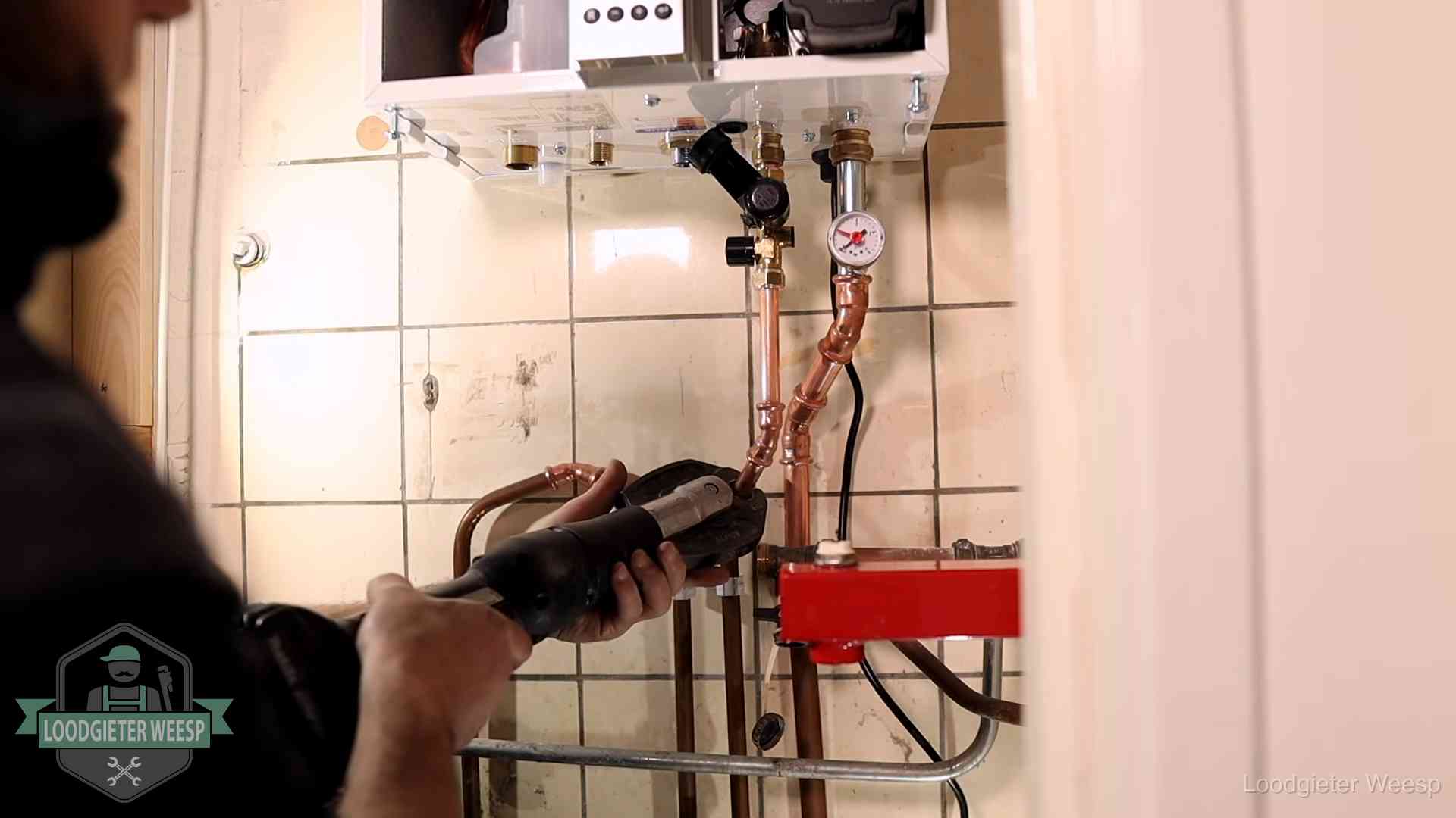 Cv-ketel onderhoud in Weesp Monteur werkt aan de leidingen onder een cv-ketel in Weesp