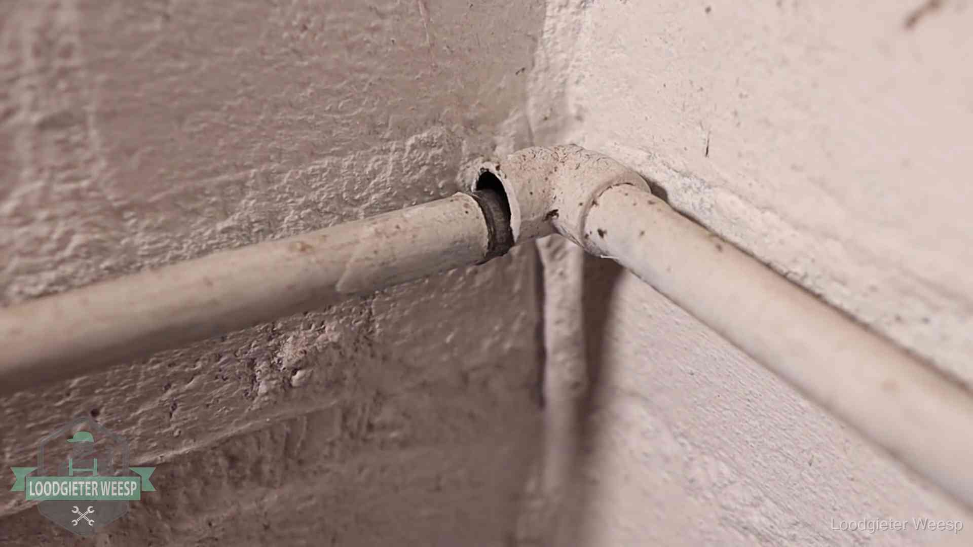 Oude waterleidingen en verborgen lekkage in Weesp Oude geverfde waterleiding met een losliggende fitting in een woning in Weesp