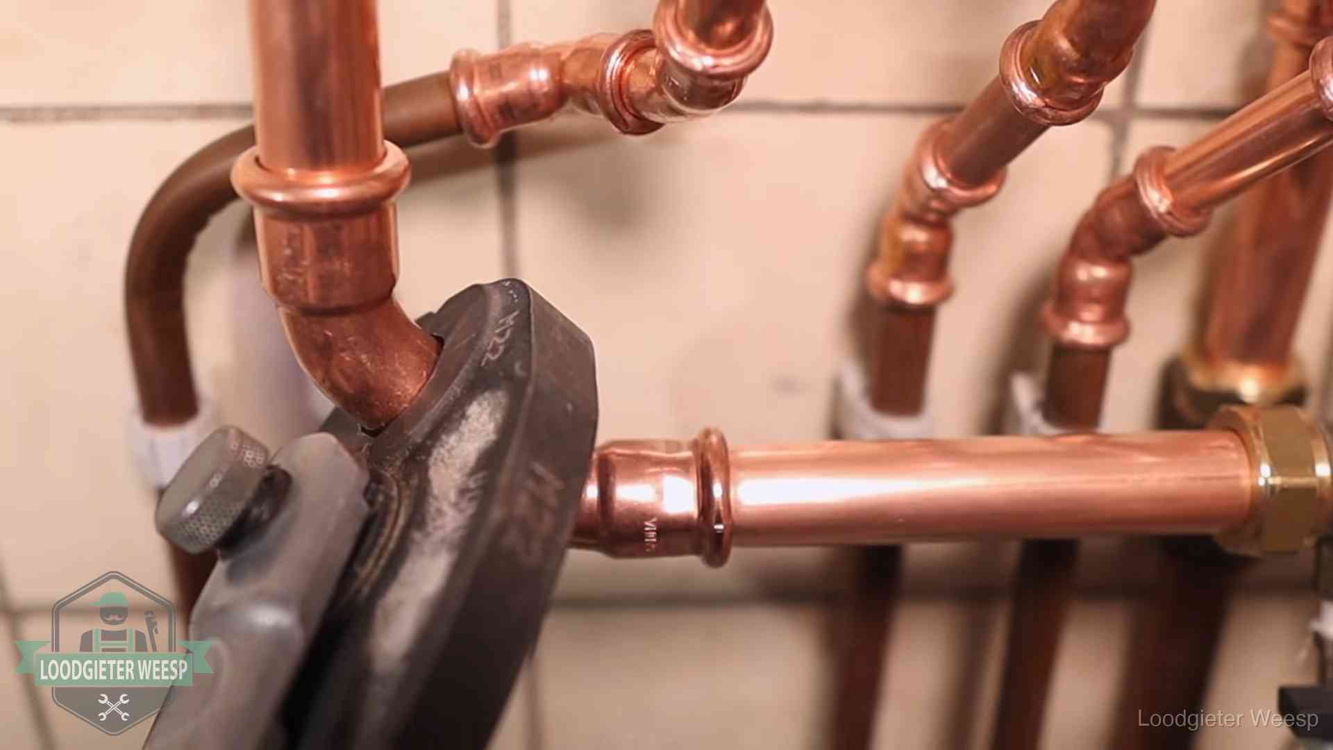 Werkwijze van ons loodgietersbedrijf in Weesp Persmachine perst een koperen fitting op nieuw leidingwerk in Weesp