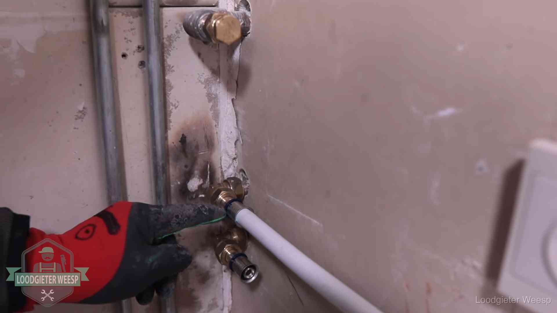 Garantie op loodgieterswerk in Weesp Loodgieter wijst de persfitting op nieuwe muuraansluitingen aan in een woning in Weesp
