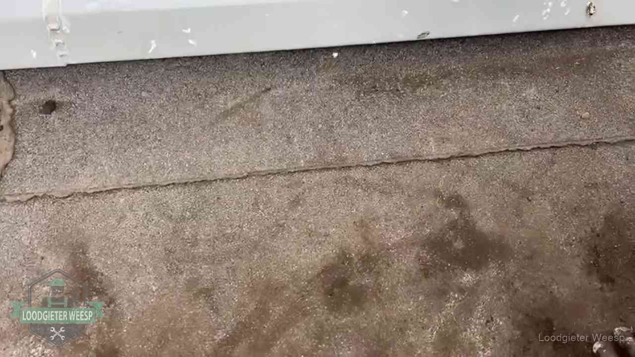 Vochtplekken bij de naad van een plat dak na aanhoudende regen in Weesp