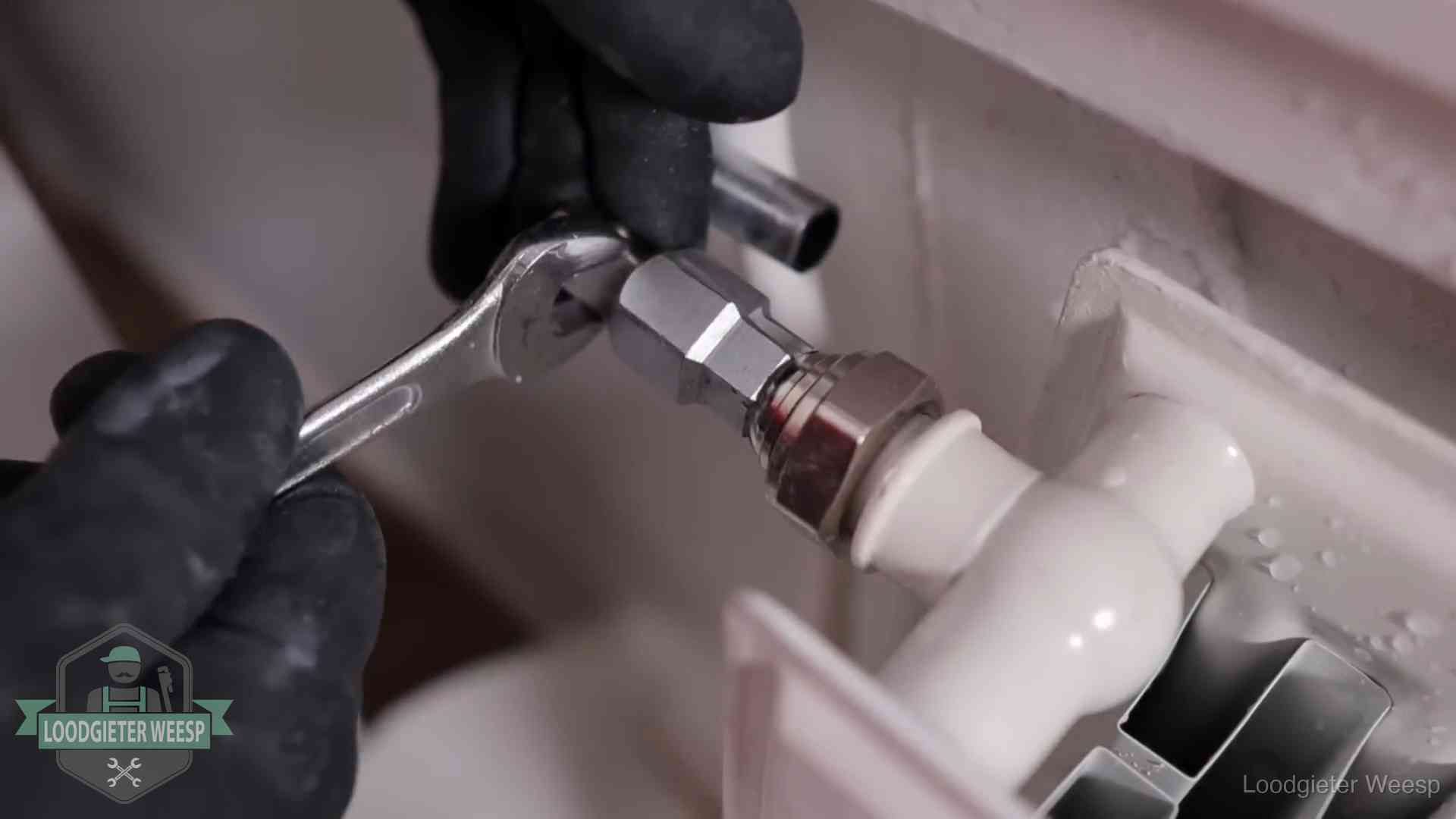 Radiatoren en waterzijdig inregelen in Weesp Steeksleutel draait een wartelkoppeling op een radiatorkraan aan in Weesp
