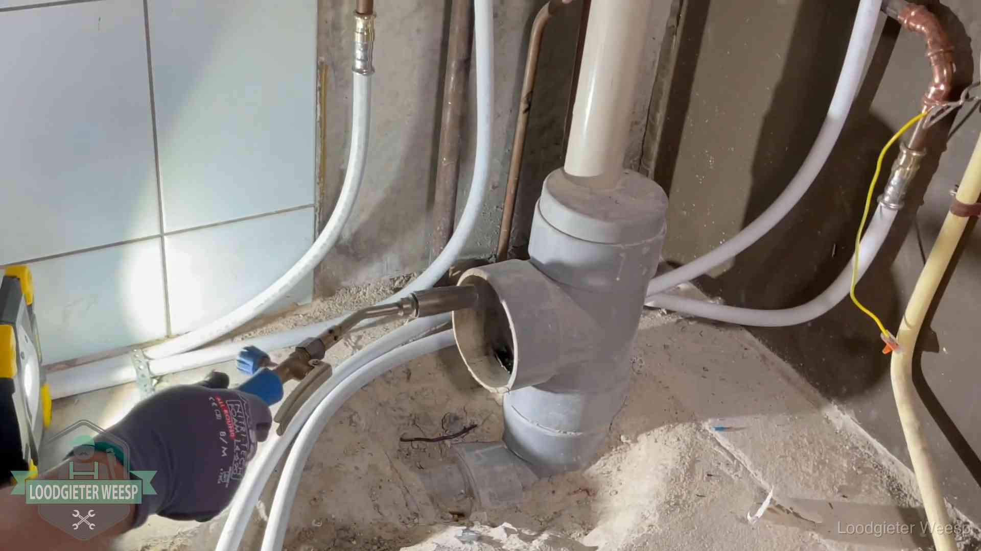 Loodgieter werkt aan leidingen bij de pvc-standleiding van een huurwoning in Weesp