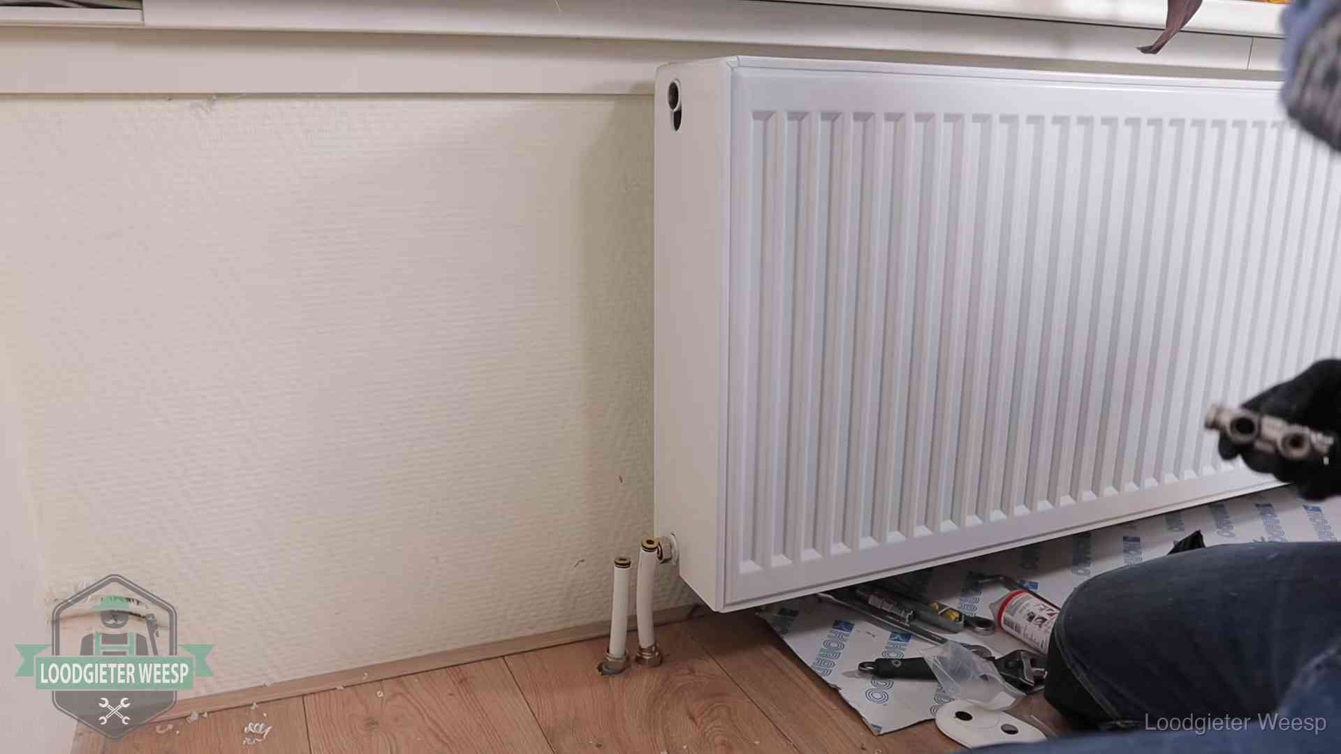 Verwarming per wijk in Weesp Nieuw gemonteerde radiator in een woonkamer in Weesp