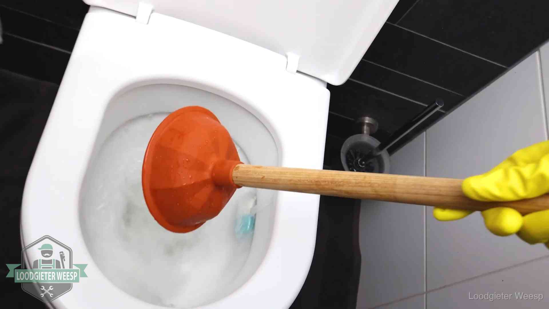 Wc ontstoppen met de plopper in Weesp Plopper wordt in de wc-pot gedrukt bij het ontstoppen van een toilet in Weesp