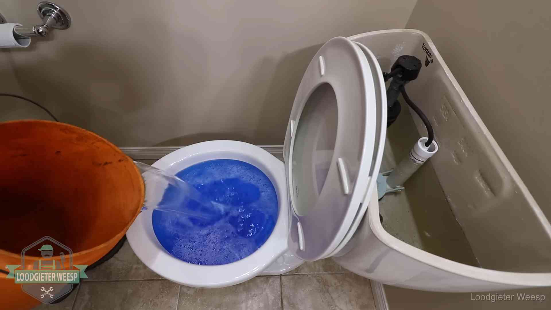 Water komt omhoog in de wc in Weesp Water bij de wc-pot wordt met een emmer weggewerkt om schade te beperken in Weesp